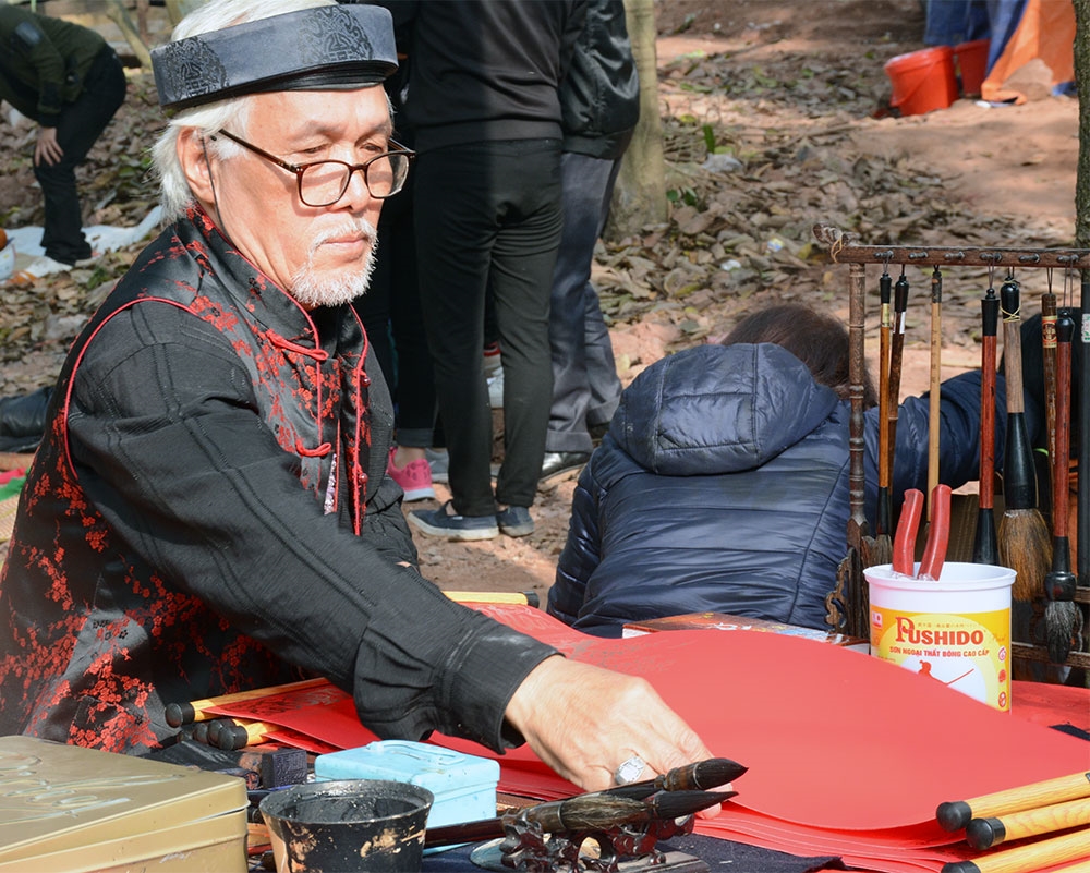 Ông Đồ chuẩn bị dụng cụ để cho chữ, làm cho sắc xuân của lễ hội rực rỡ hơn.